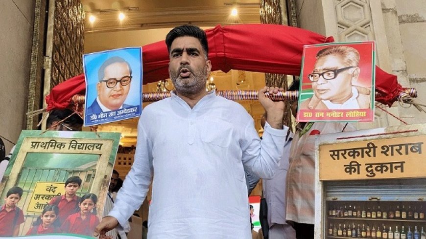 यूपी विधानसभा मानसून सत्र में सपा विधायक अतुल प्रधान एक अनोखी कांवड़ लेकर पहुंचे, स्कूल और शराब दुकान की तस्वीरों के साथ सरकार पर निशाना। 